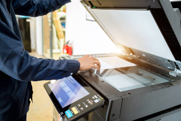 Bussiness man Hand press button on panel of printer, printer scanner laser office copy machine supplies start concept.