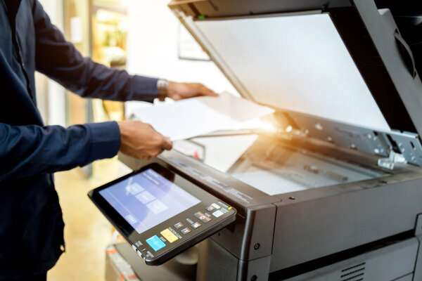 Bussiness man Hand press button on panel of printer, printer scanner laser office copy machine supplies start concept.