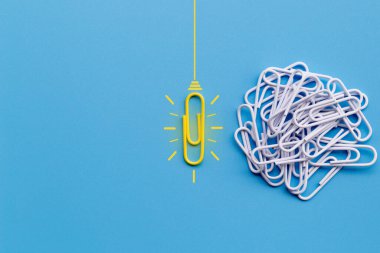 Kağıt ataç, düşünme, yaratıcılık, mavi arka planda ampul, yeni fikirler kavramı ile harika fikirler..