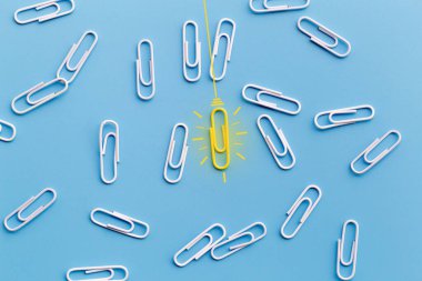 Kağıt ataç, düşünme, yaratıcılık, mavi arka planda ampul, yeni fikirler kavramı ile harika fikirler..