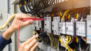 Elektrikçiler kontrol panelinde elektrik akımını test ediyorlar.