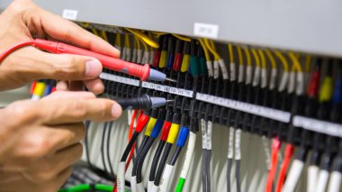 Elektrikçiler kontrol panelinde elektrik akımını test ediyorlar.