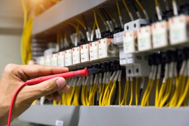 Elektrikçiler kontrol panelinde elektrik akımını test ediyorlar.