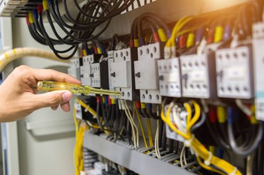 Elektrikçiler kontrol panelinde elektrik akımını test ediyorlar.