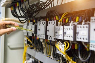 Elektrikçiler kontrol panelinde elektrik akımını test ediyorlar.