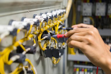 Elektrikçiler kontrol panelinde elektrik akımını test ediyorlar.
