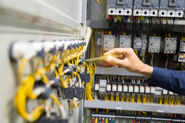 Elektrikçiler kontrol panelinde elektrik akımını test ediyorlar.