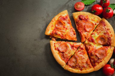 Acı biberli pizza, lezzetli biberli pizza ve siyah arka planda domates fesleğeni..