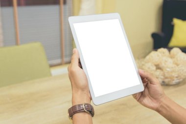 İş adamlarının elindeki tablet ev masadaki bulanık arkaplanlı boş ekran.