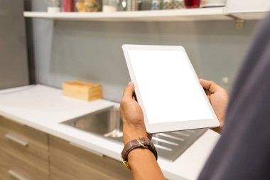 İş adamlarının elindeki tablet ev masadaki bulanık arkaplanlı boş ekran.