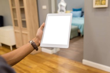 İş adamlarının elindeki tablet ev masadaki bulanık arkaplanlı boş ekran.