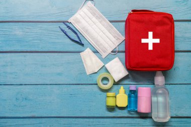 Ahşap arka planda tıbbi malzemeleri olan ilk yardım çantası taşıyan çocuk..