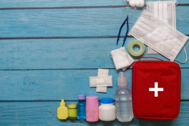 Ahşap arka planda tıbbi malzemeleri olan ilk yardım çantası taşıyan çocuk..