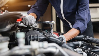 Otomobil tamircisi elleri ingiliz anahtarı, araba servisi ve bakımı ile bir araba motoru otomotiv atölyesini tamir ediyor..