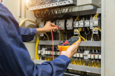 Elektrik mühendisi, kabine kontrolündeki voltaj ve elektrik hattının akımını ölçen bir testçi..
