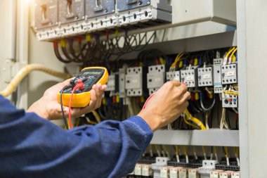 Elektrik mühendisi, kabine kontrolündeki voltaj ve elektrik hattının akımını ölçen bir testçi..