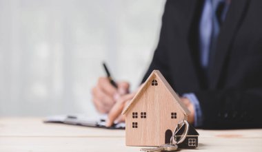 Buy or Rent 'le çalışan iş adamı, kopyalama alanı. Mülk yatırımı ve ev kredisi finansal konsepti El 'in ahşap eve para yığını koyması..