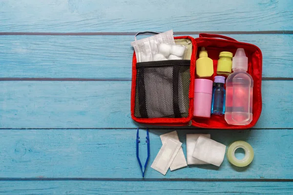 Ahşap arka planda tıbbi malzemeleri olan ilk yardım çantası taşıyan çocuk..