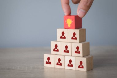 Elle seçilen odun küpü ikon ampul ve insan sembolü, yaratıcı fikir ve yenilik kavramı.