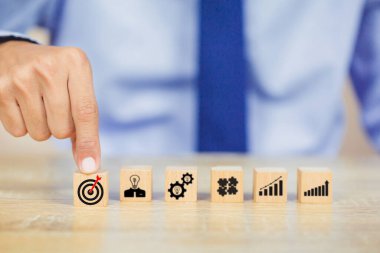 İş ellerinin ahşap bloğu düzenlemesi. Hedef, fikir, liderlik, zaman yönetimi, Bilgi, Girişim, İnsan İlişkileri içeren iş stratejisi ikonu