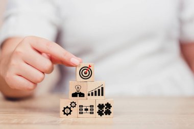 İş ellerinin ahşap bloğu düzenlemesi. Hedef, fikir, liderlik, zaman yönetimi, Bilgi, Girişim, İnsan İlişkileri içeren iş stratejisi ikonu