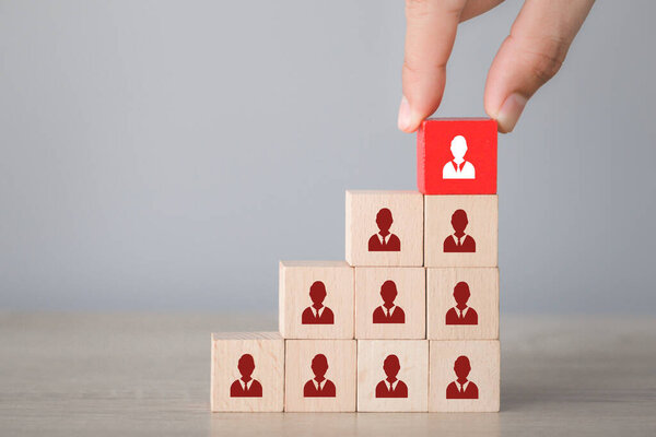 Hand choosing wood cube with icon light bulb and human symbol,creative idea and innovation concept.