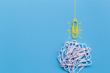 Kağıt ataç, düşünme, yaratıcılık, mavi arka planda ampul, yeni fikirler kavramı ile harika fikirler..