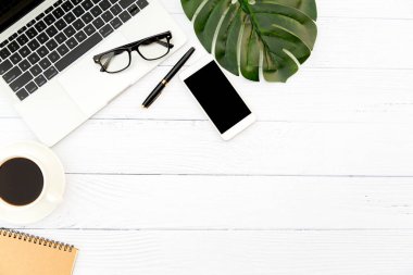 Ofiste çalışma alanı, boş defterli ahşap beyaz masa ve diğer ofis malzemeleri, fotokopi alanı olan üst görünüm..