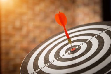 Kırmızı dart oku hedef tahtanın ortasına güneş ışığı klasik tarzıyla vuruyor, hedef pazarlama ve iş başarısı konsepti - görüntü.