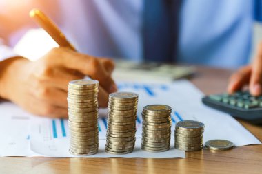 Yakın plan, madeni para yatırımı, yatırım, tasarruf ve bankacılık kavramını ofisindeki masanın üzerine koyan insanlar..