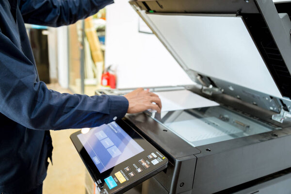 Bussiness man Hand press button on panel of printer, printer scanner laser office copy machine supplies start concept.