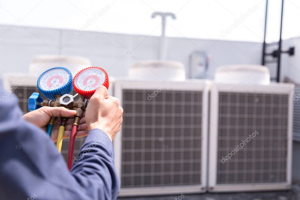 Technician is checking air conditioner ,measuring equipment for filling air conditioners.