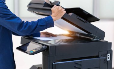 İşadamı, yazıcı fotokopi ağı panelindeki düğmeye basar, ofis konseptinde fotokopi üzerinde çalışır, yazıcı, kağıt tarama ve kopyalama için ofis çalışanı ekipmanıdır.