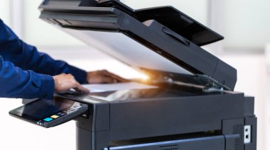 İşadamı, yazıcı fotokopi ağı panelindeki düğmeye basar, ofis konseptinde fotokopi üzerinde çalışır, yazıcı, kağıt tarama ve kopyalama için ofis çalışanı ekipmanıdır.