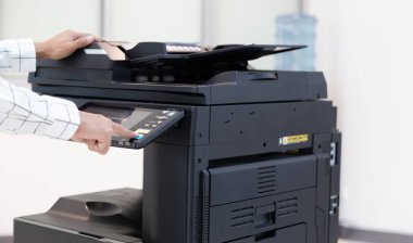 İşadamı, yazıcı fotokopi ağı panelindeki düğmeye basar, ofis konseptinde fotokopi üzerinde çalışır, yazıcı, kağıt tarama ve kopyalama için ofis çalışanı ekipmanıdır.
