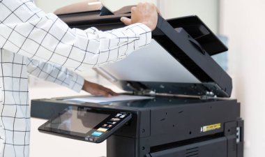 İşadamı, yazıcı fotokopi ağı panelindeki düğmeye basar, ofis konseptinde fotokopi üzerinde çalışır, yazıcı, kağıt tarama ve kopyalama için ofis çalışanı ekipmanıdır.