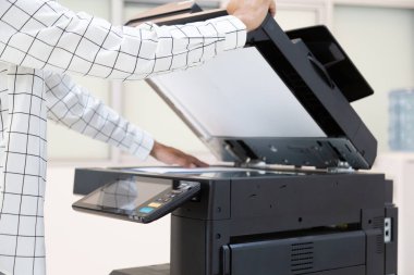 İşadamı, yazıcı fotokopi ağı panelindeki düğmeye basar, ofis konseptinde fotokopi üzerinde çalışır, yazıcı, kağıt tarama ve kopyalama için ofis çalışanı ekipmanıdır.