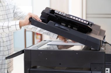 İşadamı, yazıcı fotokopi ağı panelindeki düğmeye basar, ofis konseptinde fotokopi üzerinde çalışır, yazıcı, kağıt tarama ve kopyalama için ofis çalışanı ekipmanıdır.