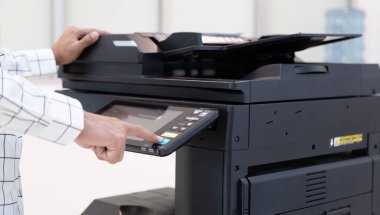 İşadamı, yazıcı fotokopi ağı panelindeki düğmeye basar, ofis konseptinde fotokopi üzerinde çalışır, yazıcı, kağıt tarama ve kopyalama için ofis çalışanı ekipmanıdır.