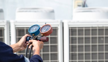 Teknisyen klimayı kontrol ediyor, klimaları, servis ve bakım klimalarını doldurmak için ölçüm aletleri kullanıyor. .