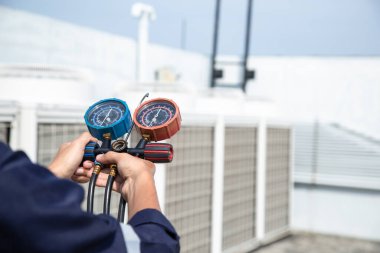 Teknisyen klimayı kontrol ediyor, klimaları, servis ve bakım klimalarını doldurmak için ölçüm aletleri kullanıyor. .
