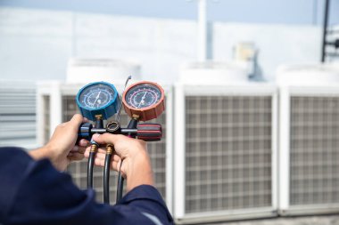 Teknisyen klimayı kontrol ediyor, klimaları, servis ve bakım klimalarını doldurmak için ölçüm aletleri kullanıyor. .