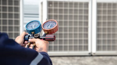 Teknisyen klimayı kontrol ediyor, klimaları, servis ve bakım klimalarını doldurmak için ölçüm aletleri kullanıyor. .
