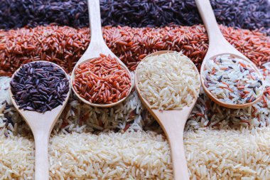 Ahşap bir kaşıkta dört sıra pirincin üst görüntüsüne sahip yiyecek arka planı.