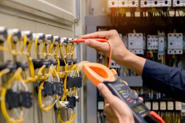 Elektrik mühendisi, kabine kontrolündeki voltaj ve elektrik hattının akımını ölçen bir testçi..