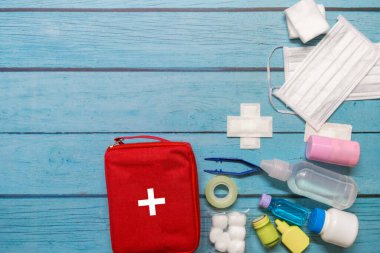 Ahşap arka planda tıbbi malzemeleri olan ilk yardım çantası taşıyan çocuk..