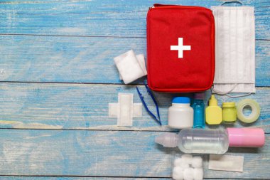 Ahşap arka planda tıbbi malzemeleri olan ilk yardım çantası taşıyan çocuk..