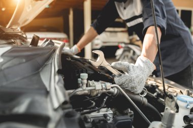 Otomobil tamircisi elleri ingiliz anahtarı, araba servisi ve bakımı ile bir araba motoru otomotiv atölyesini tamir ediyor..