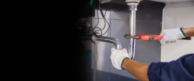 Tesisatçı ayarlanabilir anahtarla beyaz lavabo borusunu tamir ediyor..