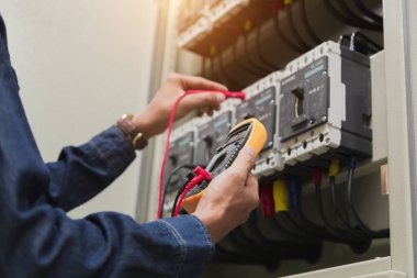 Elektrik mühendisi, kabine kontrolündeki voltaj ve elektrik hattının akımını ölçen bir testçi..